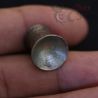 in hand close up of burmese silver ear plug surface texture