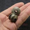 Pair of mid-20th century Burmese silver ear plugs held in hand showing size and front flare detail.