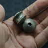 Close hand-held view of red Karen tribe silver ear tunnels from Shan State, showing patina and craftsmanship."