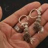 in hand side angle – pair of lahu musur silver earrings hand held side angle