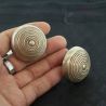 Large antique Pa-O silver ear plug in hand, side angle close-up