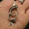 IN HAND SIDE Yao silver earrings with leaf-shaped pendants shown in hand, TOP angle.
