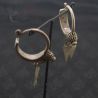 TOP SIDE ANGLE HANGING DISPLAY-7: Antique silver Yao earrings with floral finials and leaf pendants, top side view.