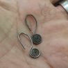 ANTIQUE SILVER YAO EARRINGS SPIRAL ORNAMENT IN HAND SIDE ANGLE VIEW