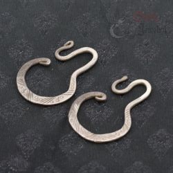 Antique Yao silver earrings top and side angle showing engraved geometric design and curved hook shape.