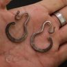 Antique Yao silver earrings held in hand showing proportion and patina.