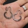 Antique Yao silver earrings hand-held close-up highlighting delicate silver alloy surface.