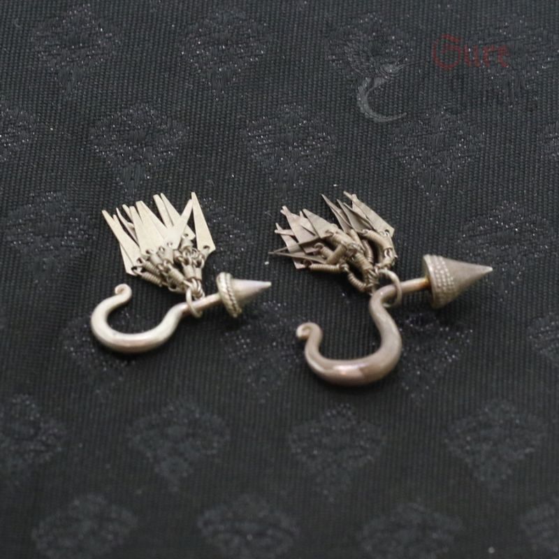 Antique silver Yao earrings top and side view showing conical finials and dangling pendants. Antique silver Yao earrings top and side view showing conical finials and dangling pendants.