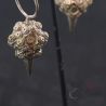 Silver Yao seed bag earrings hanging on display macro – fine craftsmanship and cultural design details