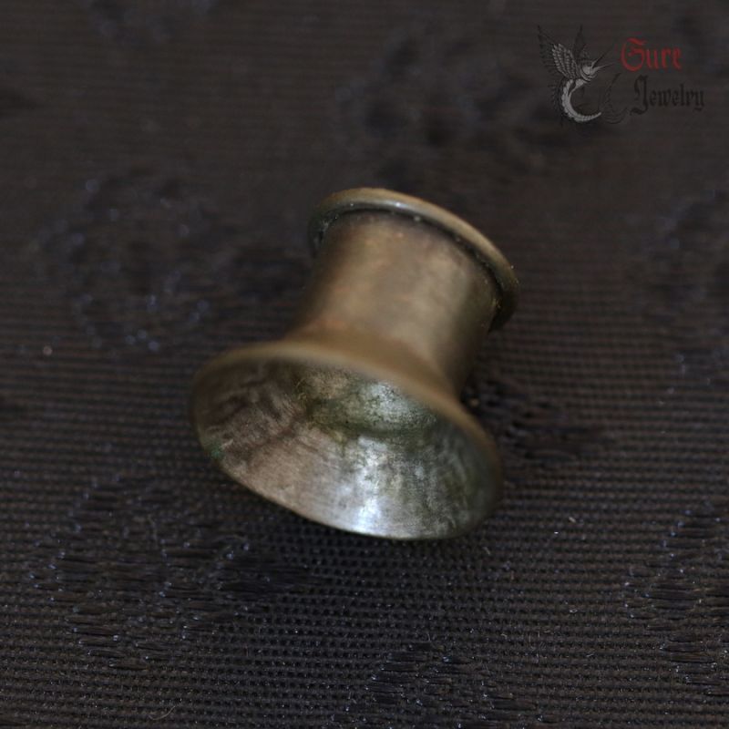 Karen hill tribe silver alloy cup ear plug top view on dark background