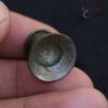 Tribal silver alloy ear plug in hand showing flared front