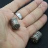Traditional Burmese silver ear plugs shown in hand, tribal jewelry side view