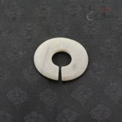 Ancient style jade like stone ear ornament slit ring top view on dark textile