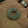 Jade like stone ear ornament held in hand showing size thickness and stone texture