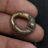 Hand-held view of antique Khmer gilded bronze omega earring showing scale and thickness