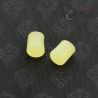 TOP SIDE ANGLE-5: Close top-side view of yellow-green glass ear plugs with natural internal variation and aged surface