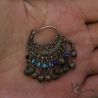 Tribal silver dangle earring in hand showing size and craftsmanship side angle