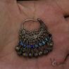 Vintage ethnic earring in hand close up crescent shape blue bead detail