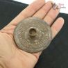 Side angle view of antique Burma frontier tribal silver ear ornament with tubular insert held in hand