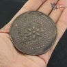 Profile view of Shan Padaung Akha silver ear spool showing repoussé hand-worked details