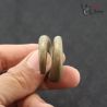 Traditional Ta Oy ear ornaments in hand showing scale and size