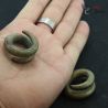 Heavy copper alloy tribal ear weights displayed in hand
